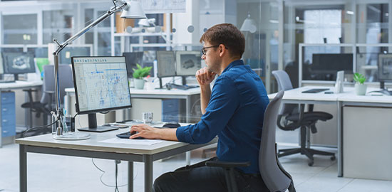 Ein Mitarbeiter analysiert Daten am Bildschirm und arbeitet an technischen Auswertungen.