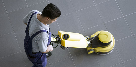 Ein Mitarbeiter reinigt einen Boden mit einer professionellen Reinigungsmaschine.
