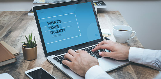 Eine Person arbeitet am Laptop, auf dem eine Seite zur beruflichen Orientierung angezeigt wird.